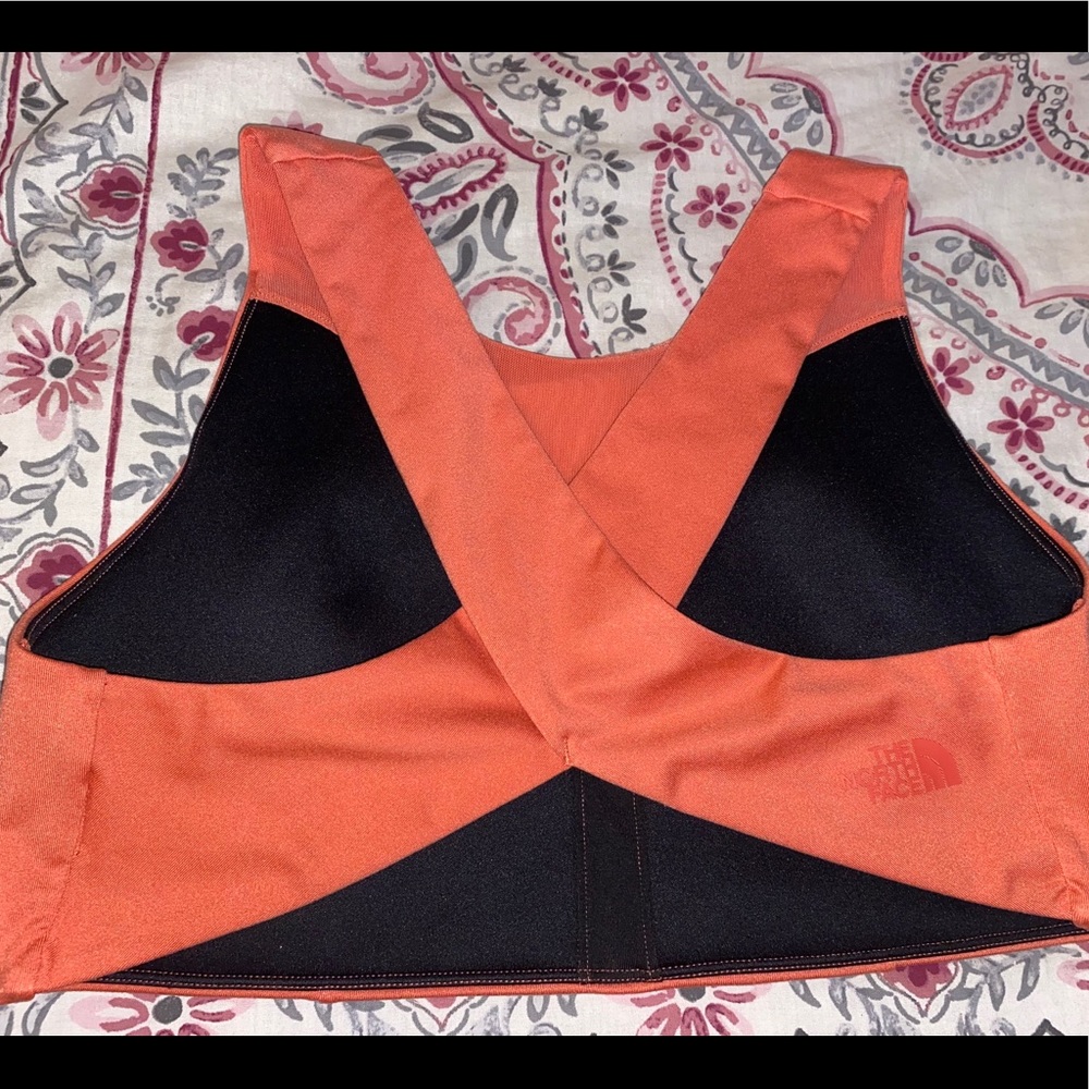 The North Face: orange criss cross sports bra